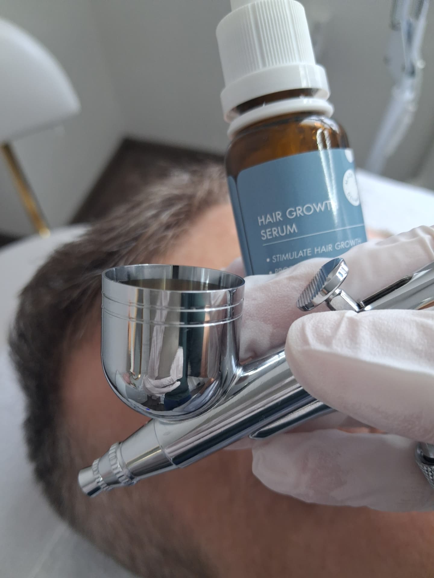 Sérum Hair Growth DermaOXY a airbrush pištoľ počas ošetrenia