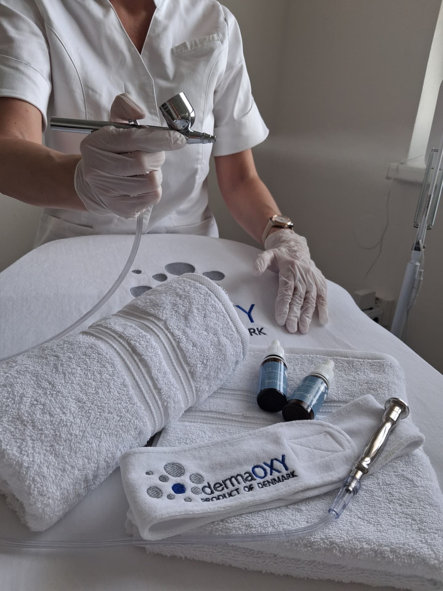 Príprava ošetrenia DermaOXY s produktmi, uterákmi a airbrush pistolkou